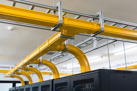 Modern data center with bright yellow cable management systems above server racks