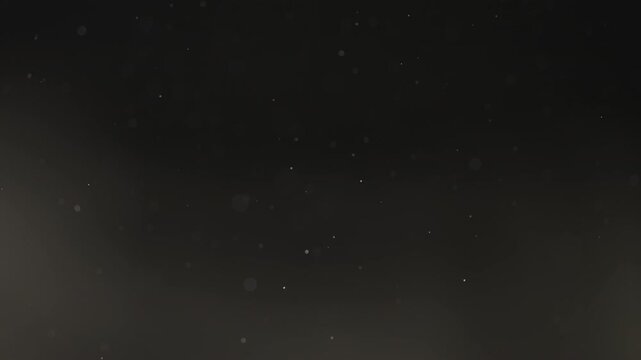 Floating dust particles over dark background with shallow focus