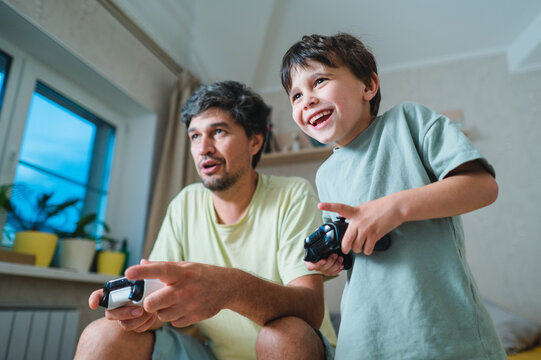 Father and son play a video game together at home