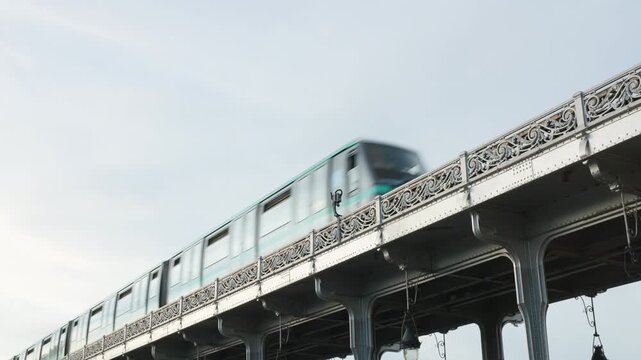 Low Angle View of a Paris Metro Train Passing Along the Ornate Upper Viaduct of Pont de Bir-Hakeim Against a Bright Sky