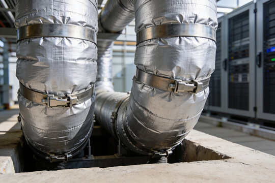 Industrial insulated pipes with metal clamps in a facility setting