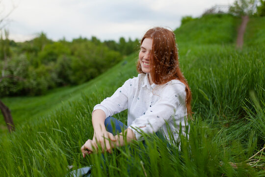 Smiling girl enjoys the green grass during summer