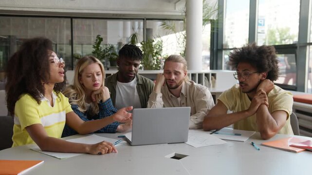 Multiethnic five students discuss laptop troubled task feeling stress classmates studying boring process online learning talking discuss difficulties study in university college e-learning overworked