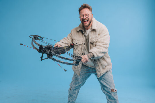 competitive crossbow shooter stands proudly against clean blue background exuding joy and focus