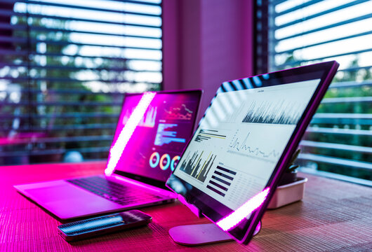 Illuminated screens display data analysis on a modern office desk