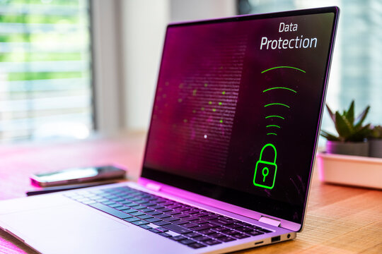 A laptop displays data protection on a wooden desk indoors