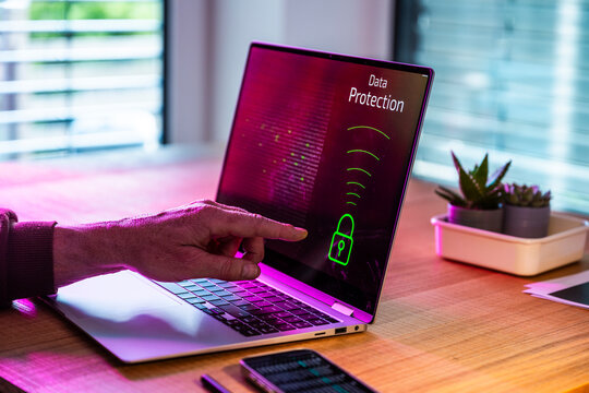 Man points at data protection on laptop screen in the office