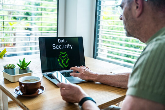 Man is working on notebook with data security screen at home office