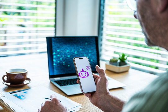 Man uses AI chatbot on mobile device at office desk