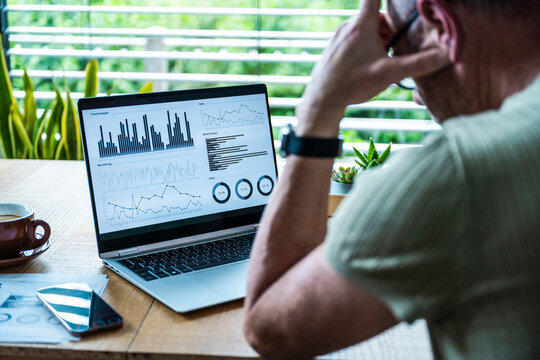 Man analyzing business data on computer screen at office desk