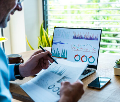 A man analyzes financial data on a notebook screen in the office