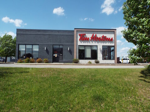 Gatineau,Quebec, Canada &ndash; May 24, 2026:A modern "Tim Hortons" restaurant storefront stands behind a green lawn, showcasing a classic caf&eacute; design en fran&ccedil;ais at 25 Chem. de la Savane.
