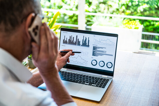 Broker analyzes data on laptop and calls smartphone in home office