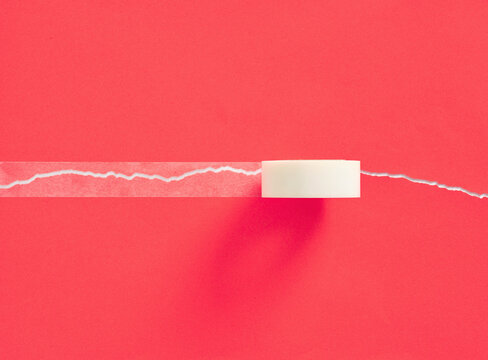 Repairing torn red paper with adhesive tape