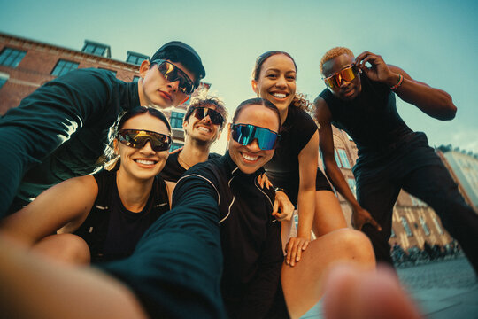 Group running friends gather for a selfie before an outdoor run club event