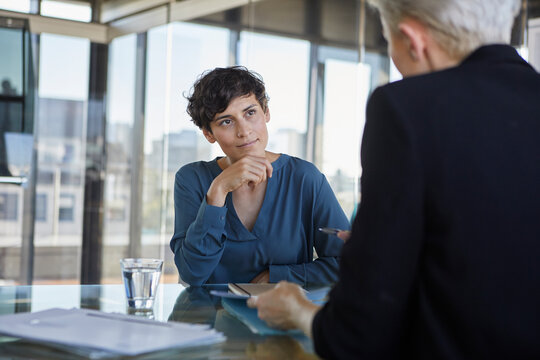 Two businesswomen talking at desk in office