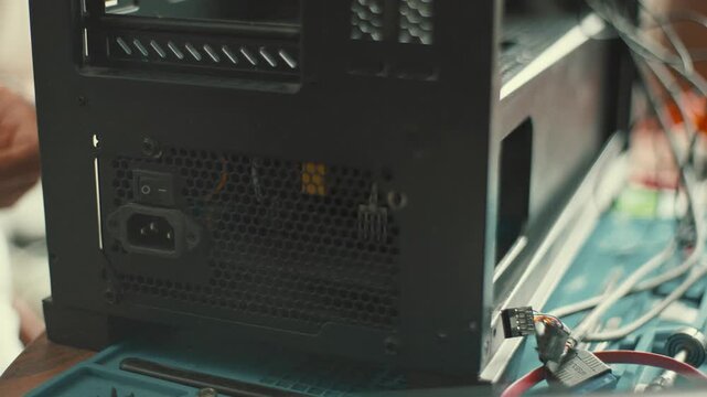Building a computer at a desk with tools and parts in a well-lit room while focusing on the power supply and cables