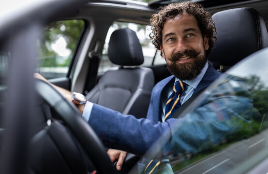 Man sits in car and smiles while driving