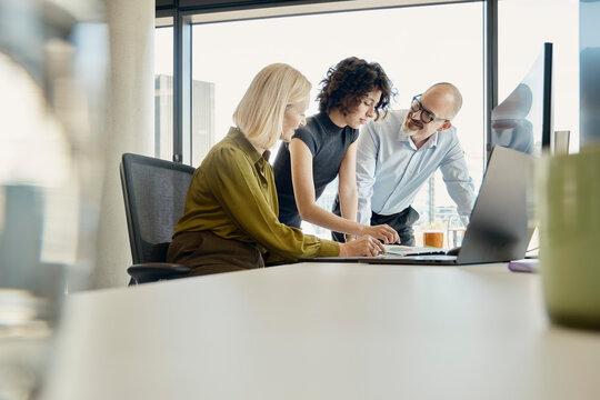 Colleagues working together at desk in modern London office