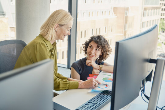 Businesswoman shows a chart to a colleague in a modern London office