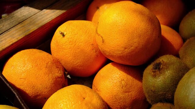 oranges and kiwis at the market. Fresh Oranges, Kiwis in Plastic Crates at an Outdoor Farmer Market