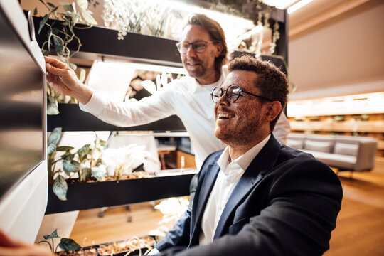 A businessman shows a screen to a colleague in the office