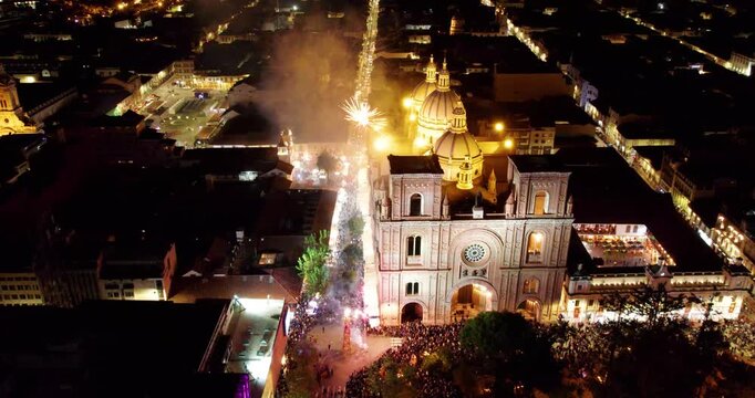 cinematic drone flying back from the immaculate conception cathedral in cuenca ecuador revealing beautiful fireworks exploding in the dark night sky during the massive corpus christi cultural festival