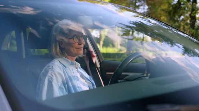 Caucasian retired woman granny sitting inside own renting car fastening seat belt smiling at camera cheerful old senior female retirement lady pensioner in rent luxury auto driver smile in automobile