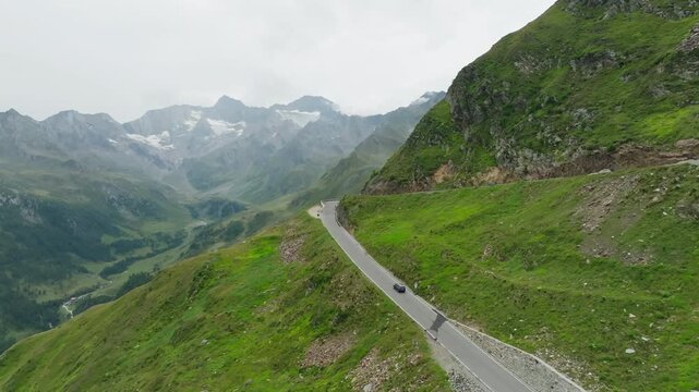 Scenic aerial panorama of a car driving across the Timmelsjoch High Alpine Road in Austria featuring winding mountain roads and unforgettable European travel