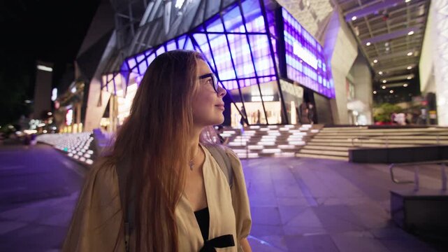 Female traveler discovering the nightlife of Orchard Road in Singapore City with illuminated streets modern architecture and unforgettable tourism experiences in Asia