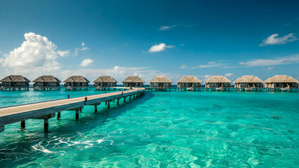 Fototapeta premium Wide angle view of tropical overwater bungalows in turquoise ocean