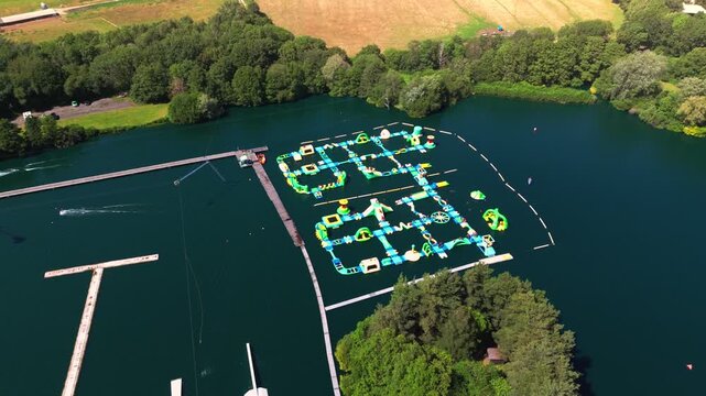 The New Forest Water Park, located near Fordingbridge in Hampshire, England, features one of the UK's first and largest outdoor floating inflatable aqua parks set on a scenic freshwater lake.