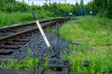 Railway switch lever located on overgrown railroad track. Manual mechanism for changing train direction on tracks. Transportation infrastructure and logistics concept in countryside. © moo