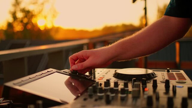 calm and focused dj mixing music on a wooden surface with sunset in the background during an outdoor setting period of time period of time period of time period of time period of time.