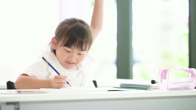 明るい教室で笑顔で手を挙げる(挙手)でハイ！と発表する小学生の女の子・授業や積極性を表現した教育、挑戦やチャレンジ、やる気や自信のイメージの動画
