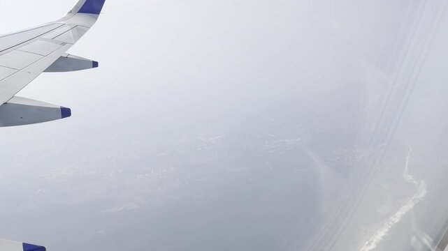 Airplane wing flying above a bright cloud layer under a dramatic blue sky, scenic aerial view from passenger window showing commercial aviation, altitude travel, freedom, journey and serene atmosphere