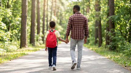 Obraz premium Father son first day back to school walk through green forest path feeling hopeful and calm. 1st day school education. happy children student classroom, childhood friendship study learning