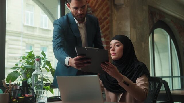 Business team Muslim businesswoman in hijab giving documents to Arabian businessman CEO boss dissatisfied with bad result financial stats problem mistake failure leaving office upset woman with laptop