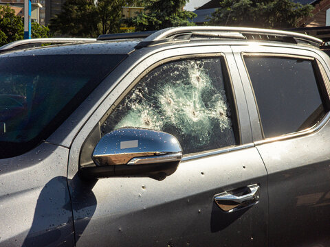 Bulletproof car window shattered by multiple gunshots after a violent shooting attack or military conflict