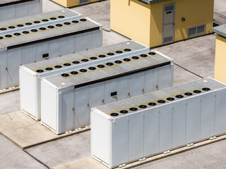 Fototapeta premium Battery energy storage system BESS installation shows several storage units in a row. The scene captures the layout of the system.