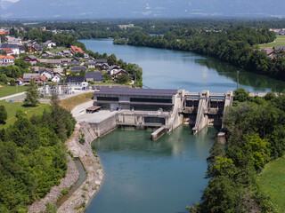 Obraz premium Hydropower plant generates clean electricity from river water. Infrastructure supports green energy production and sustainability goals.