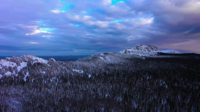 Winter mountain peak above snowy conifer forest