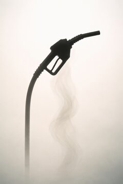 Silhouette of a fuel nozzle with vapor rising, set against a light background, emphasizing themes of energy and transportation in a minimalistic composition