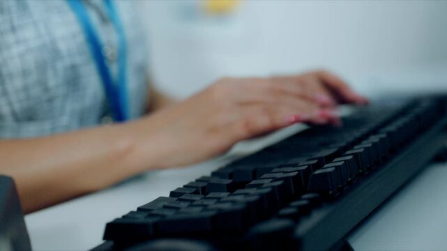 Close-up of female hands typing on a computer keyboard in a modern office, representing data entry, business communication, productivity, office workflow, and digital technology.