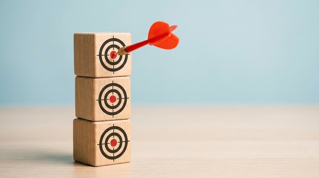 Target achievement concept dart hitting bullseye on wooden block stack