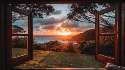 Fototapeta premium Open window revealing scenic sunset over ocean and green hillside landscape