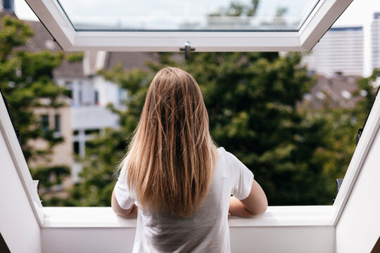 Young woman looking out of window
