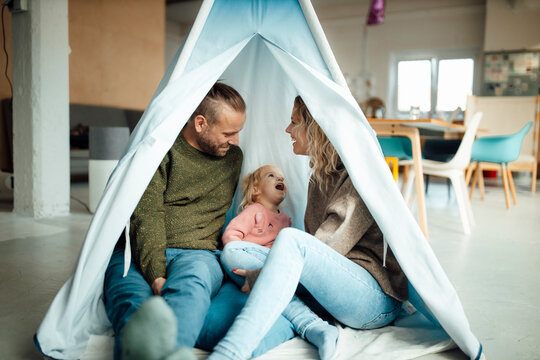 Family sitting together in tent at home
