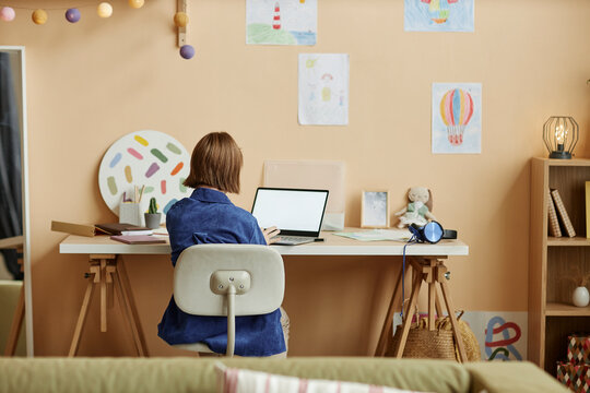 Teenage girl using laptop while studying from home