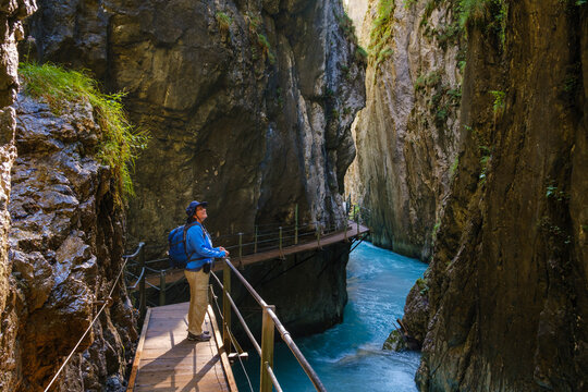 Side view of senior woman standing on footbridge at Wasserfallsteig in Leutasch Gorge, Tyrol, Austria
